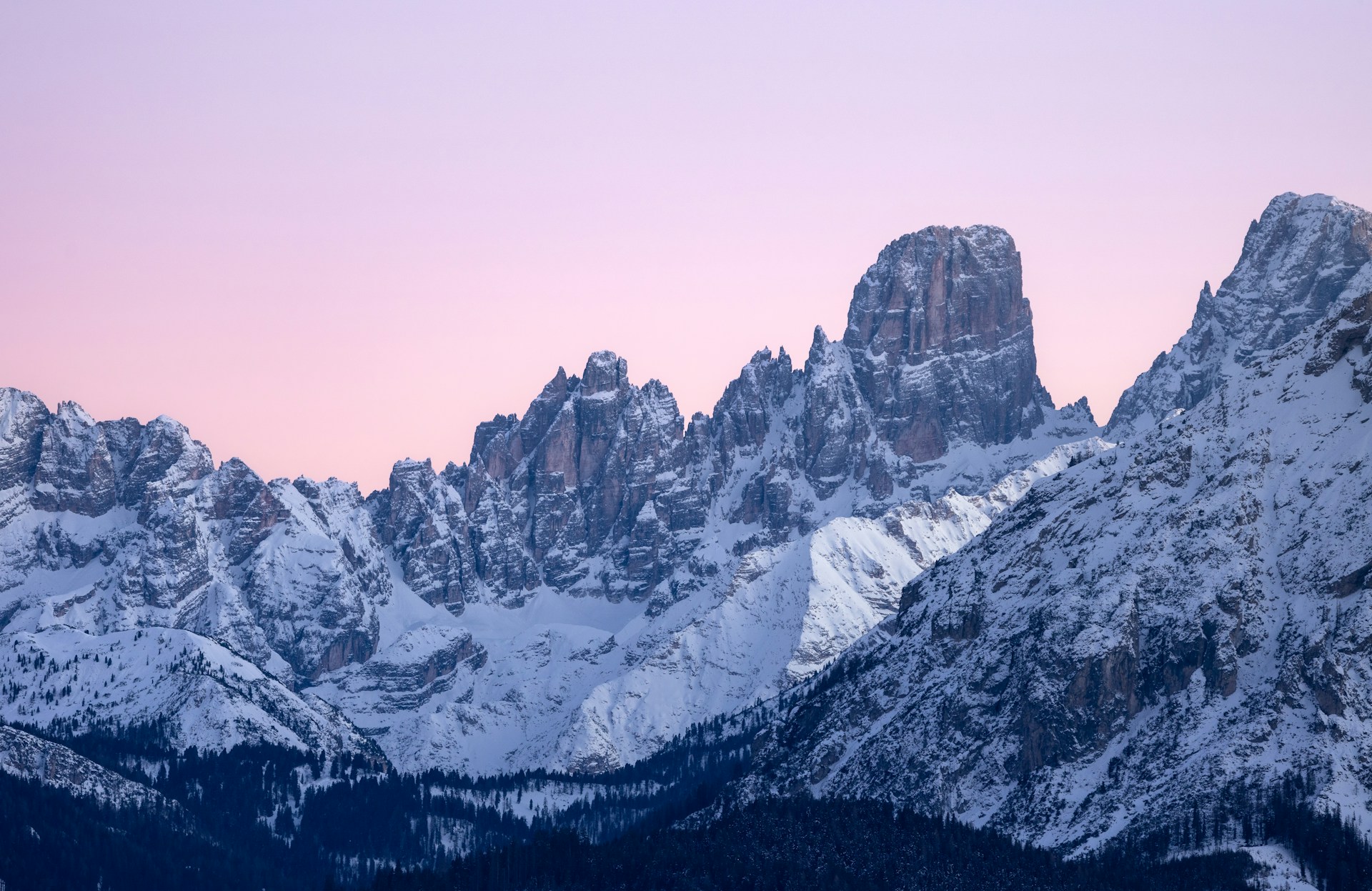 Snow-covered Dolomites peaks under a pastel sky